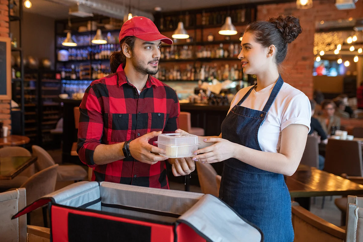 Woman giving food to man in a restaurant
